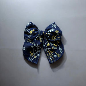 「刺繍入りのレトロシックなヘアリボン。ナチュラルカラーの生地にボタニカル柄の繊細な刺繍が施された、大きめサイズのリボンクリップ。ベビー&キッズ向けのおしゃれなヘアアクセサリー。