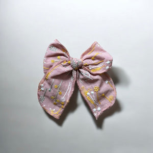 「刺繍入りのレトロシックなヘアリボン。ナチュラルカラーの生地にボタニカル柄の繊細な刺繍が施された、大きめサイズのリボンクリップ。ベビー&キッズ向けのおしゃれなヘアアクセサリー。