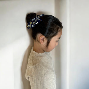 「刺繍入りのレトロシックなヘアリボン。ナチュラルカラーの生地にボタニカル柄の繊細な刺繍が施された、大きめサイズのリボンクリップ。ベビー&キッズ向けのおしゃれなヘアアクセサリー。