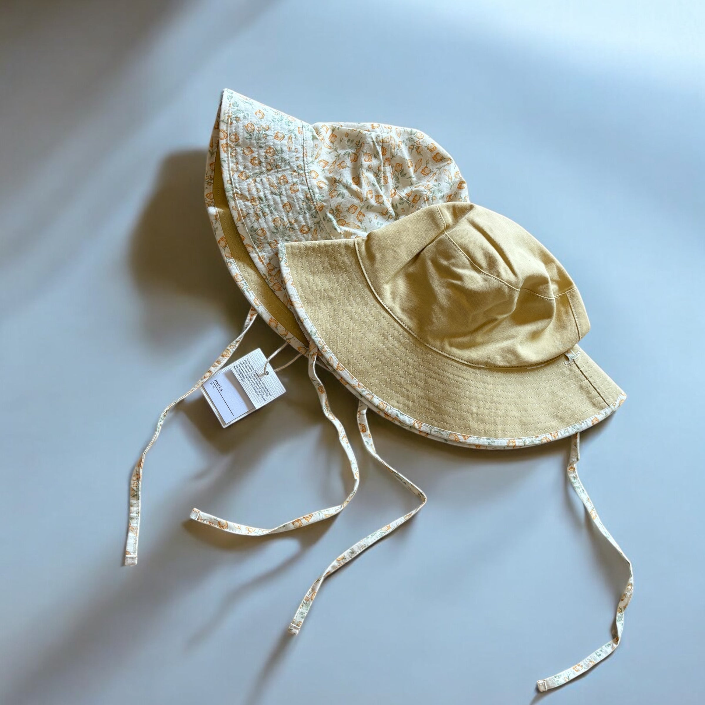 mutta.のレトロな小花柄リバーシブルキッズ帽子|イエローカラーと花柄の2WAYデザイン・あご紐付き・サイズ調整可能な春夏のおしゃれ子ども帽子