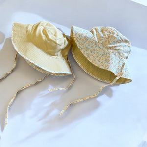 mutta.のレトロな小花柄リバーシブルキッズ帽子|イエローカラーと花柄の2WAYデザイン・あご紐付き・サイズ調整可能な春夏のおしゃれ子ども帽子