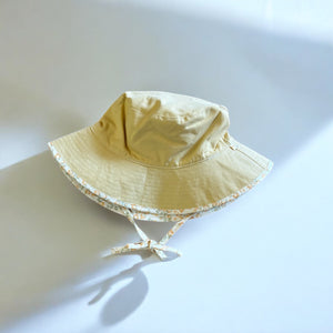 mutta.のレトロな小花柄リバーシブルキッズ帽子|イエローカラーと花柄の2WAYデザイン・あご紐付き・サイズ調整可能な春夏のおしゃれ子ども帽子