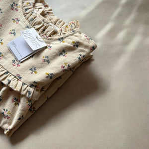 mutta.の女の子向けの秋冬ワンピース。愛らしい小花柄をちりばめた上品なベージュカラーワンピース