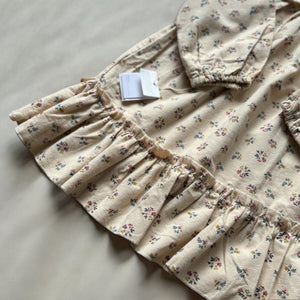 mutta.の女の子向けの秋冬ワンピース。愛らしい小花柄をちりばめた上品なベージュカラーワンピース