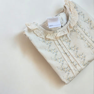 春の新作ガールズセットアップ。繊細な小花柄とレースが上品なトップスに、ふんわりシルエットのシャーリングパンツを合わせたナチュラルなコーデ。柔らかなコットン素材で快適な着心地と可愛らしさを両立