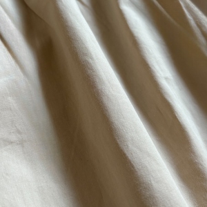 ベージュのクラシカルワンピースを着る女の子。胸元に小花柄とレースが施され、秋冬のお出かけや家族写真にぴったりの子供服