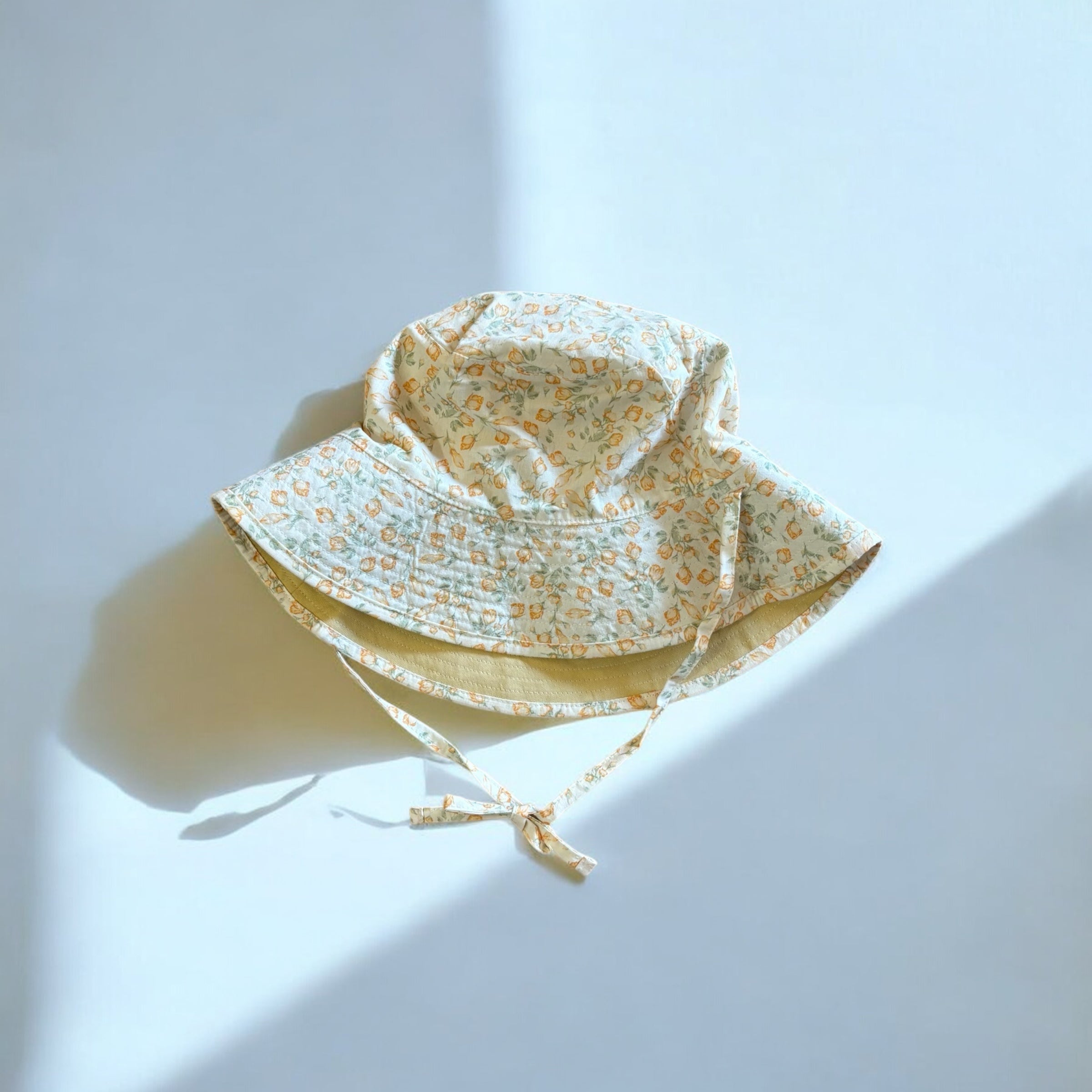 mutta.のレトロな小花柄リバーシブルキッズ帽子｜イエローカラーと花柄の2WAYデザイン・あご紐付き・サイズ調整可能な春夏のおしゃれ子ども帽子