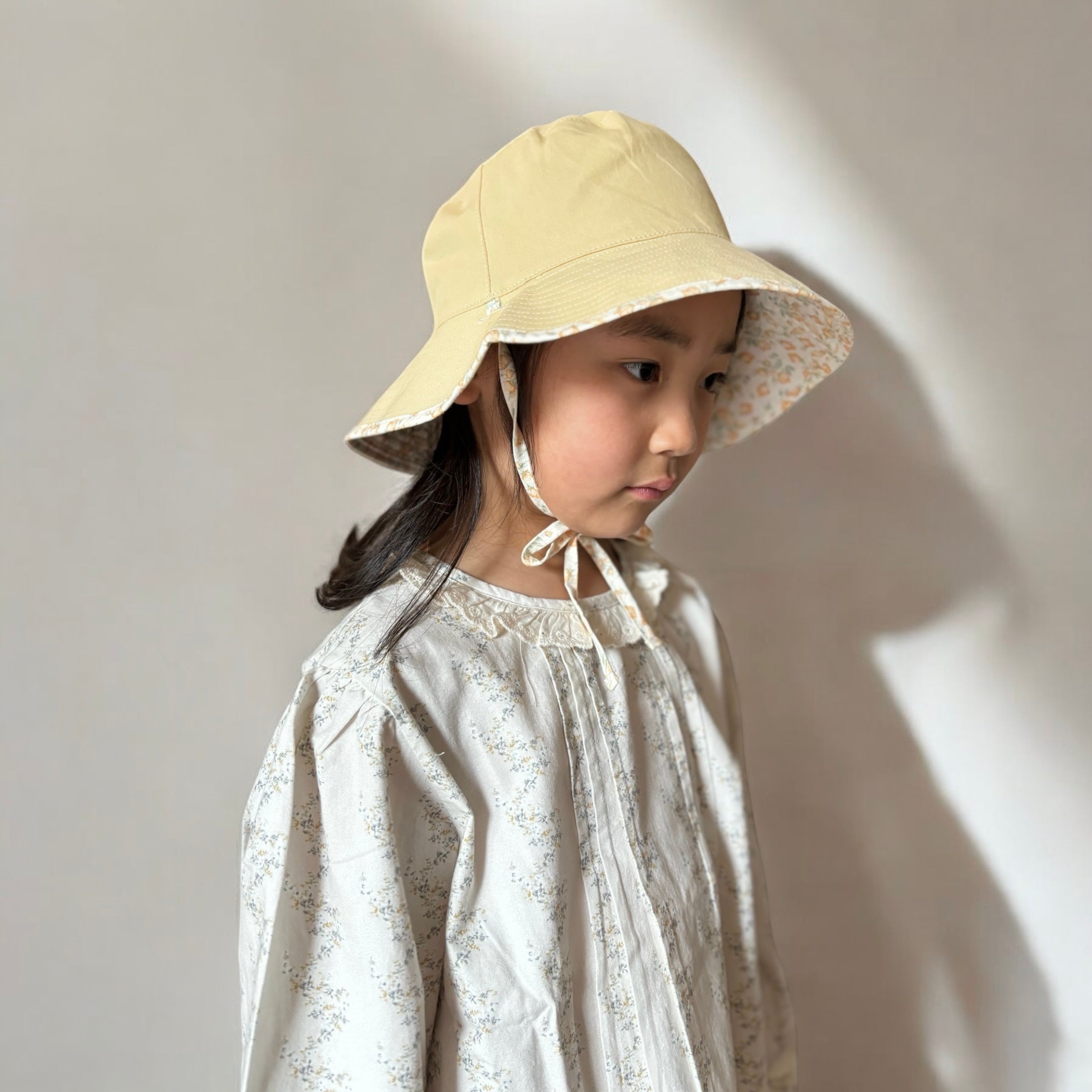 mutta.のレトロな小花柄リバーシブルキッズ帽子｜イエローカラーと花柄の2WAYデザイン・あご紐付き・サイズ調整可能な春夏のおしゃれ子ども帽子