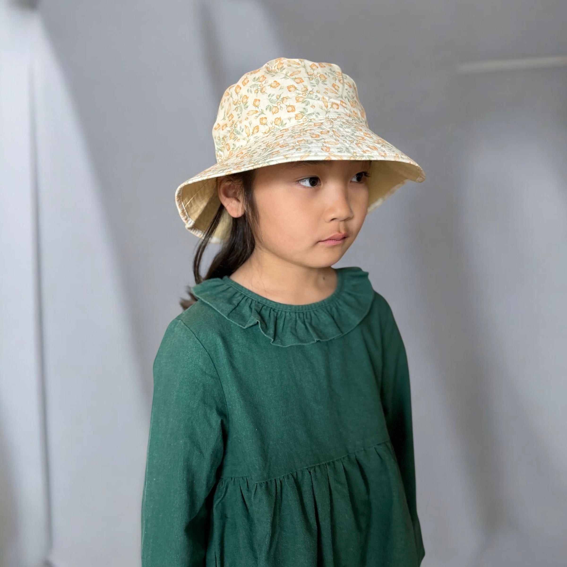 mutta.のレトロな小花柄リバーシブルキッズ帽子｜イエローカラーと花柄の2WAYデザイン・あご紐付き・サイズ調整可能な春夏のおしゃれ子ども帽子