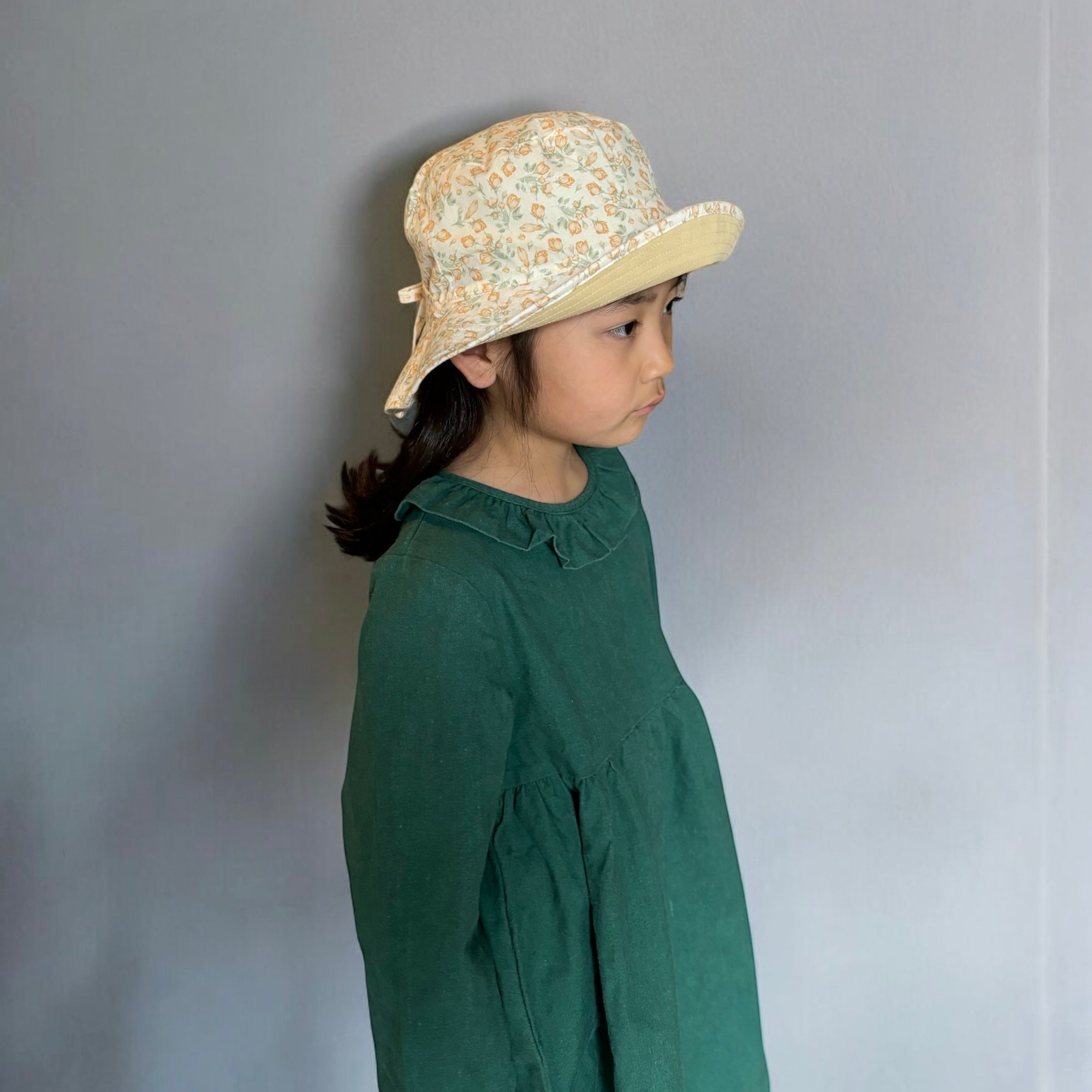 mutta.のレトロな小花柄リバーシブルキッズ帽子｜イエローカラーと花柄の2WAYデザイン・あご紐付き・サイズ調整可能な春夏のおしゃれ子ども帽子