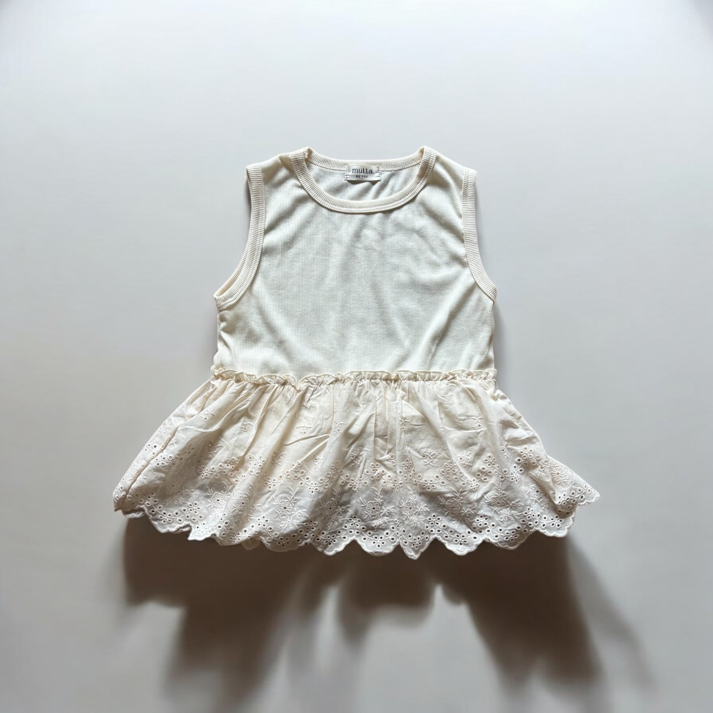 女の子用、レースフリル付きノースリーブトップス。涼しげなコットン素材で、夏のおしゃれにぴったりな子供服アイテム。