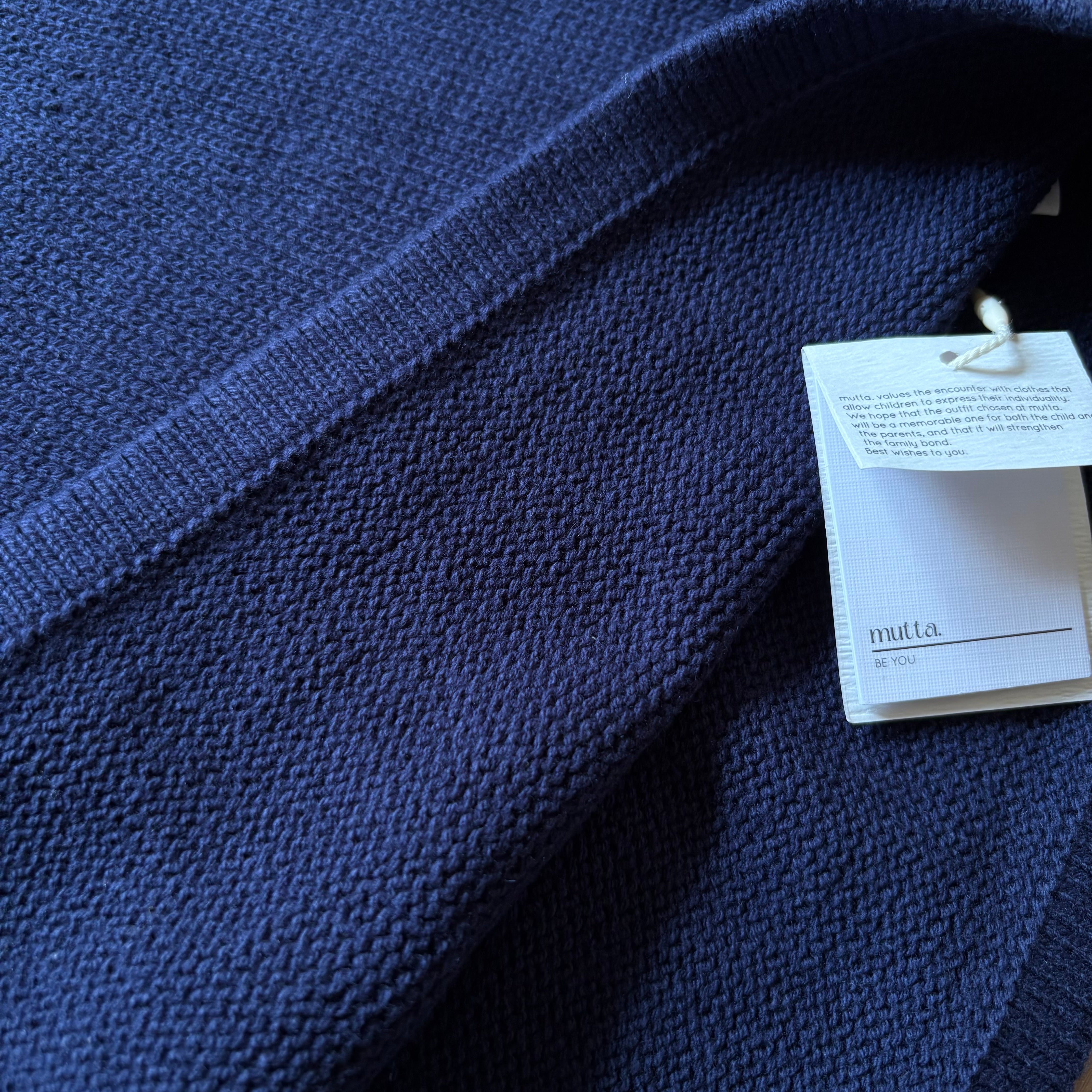 キャメルとネイビーの上品な配色が印象的な半袖ニットワンピース。秋冬のお出かけや記念日にも似合うクラシカルな1着。