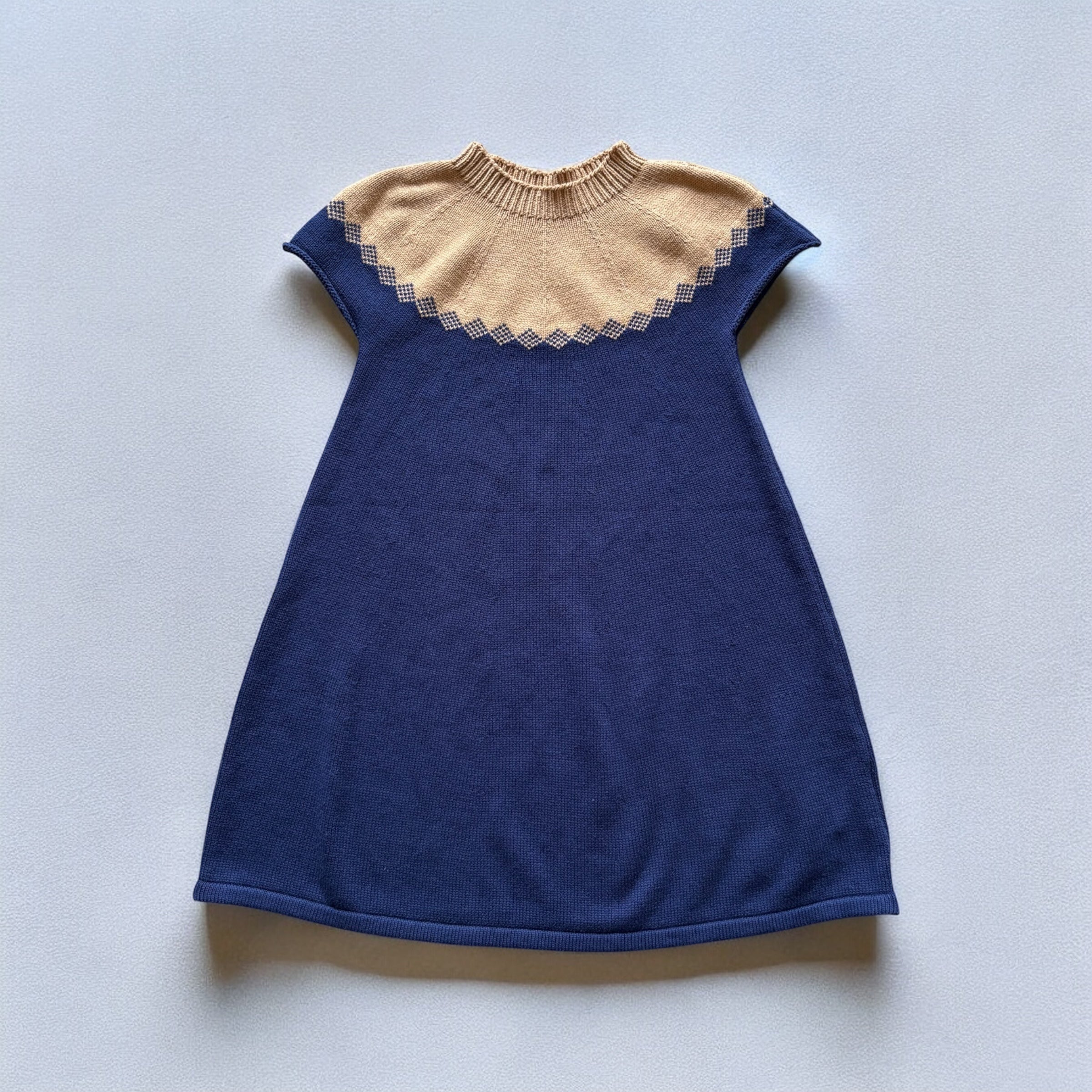 キャメルとネイビーの上品な配色が印象的な半袖ニットワンピース。秋冬のお出かけや記念日にも似合うクラシカルな1着。