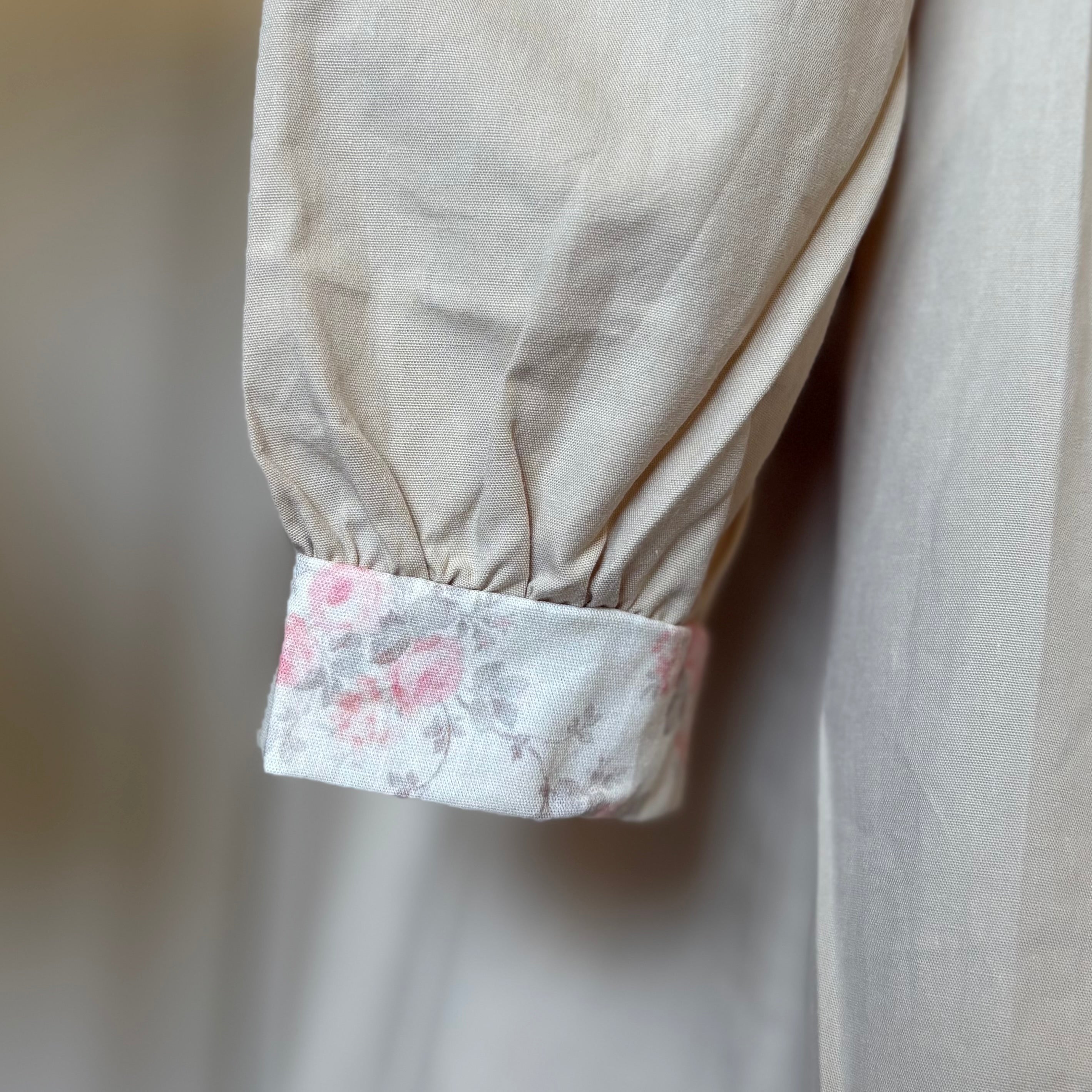 ベージュのクラシカルワンピースを着る女の子。胸元に小花柄とレースが施され、秋冬のお出かけや家族写真にぴったりの子供服